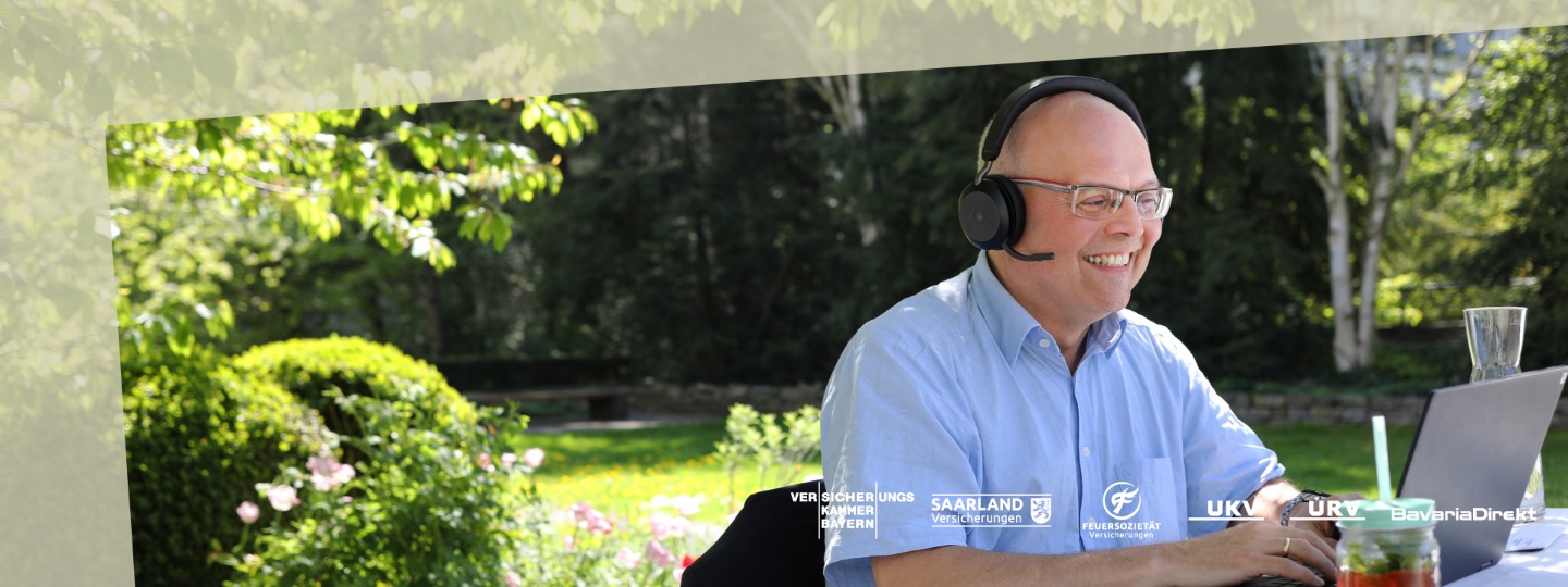 "Glücklicher Mitarbeiter im Garten am Laptop"
